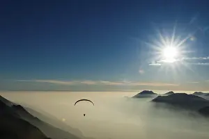 Paraglider Over Water Prints: Paraglider over the mountains in clouds