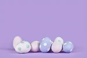 Pastel Colored Easter Eggs Prints: Pastel colored easter eggs on violet background with copy space