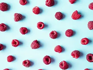 Flat Lay Fruit Photography Prints: Pattern of ripe red raspberry on blue background