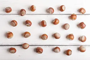 Wooden Background Studio Shot Prints: Pattern and texture made from hazelnuts on white wooden background