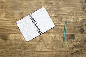 Empty Desk Space Prints: Pencil and open notebook on the table.Top view