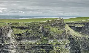 Cliffs Of Moher Ireland Prints: People walking on a path on top of the Cliffs of Moher on a overcast