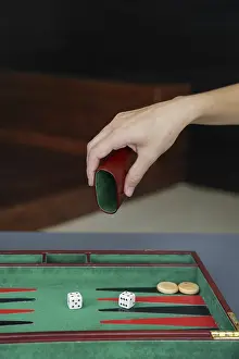 Classic Board Games Prints: A person rolls on a backgammon board