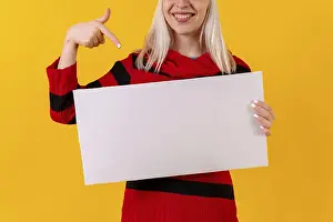 Studio Shot Yellow Background Prints: Pointing to an empty ad poster