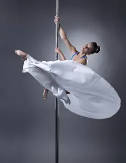 Artistic Pose Prints: Pole dance. Pretty dancer posing in elegant position