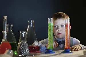Boy Looking At Camera Prints: Portrait of adorable boy posing in studio with flasks