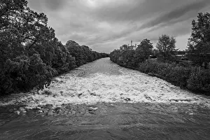 Deserted Austrian Countryside Scene Prints: A powerful river with a strong current under a cloudy sky