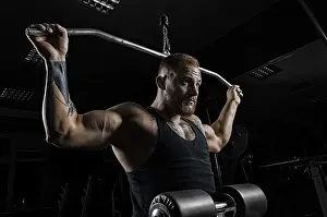 Fitness Training For Men Prints: Professional athlete performs an exercise in the gym