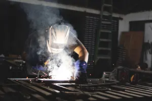 Factory Worker Safety Prints: Professional welder working at the workbench