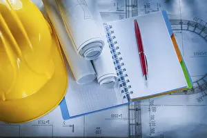 Studio Shot Construction Plan Prints: Protective hard hat checked notebook pen blueprints on construction plan