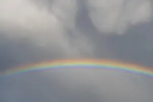 Prismatic Colors In Spring Prints: Rainbow appears in rain clouds in spring