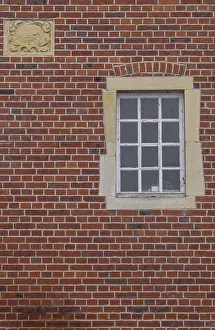 Red Brick Facade Prints: A rectangular window and a coat of arms in a red brick facade