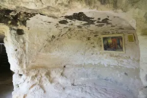 Medieval Rock Monastery Prints: A rock cave with a mural and an information panel