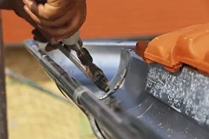 Residential Building Repair Prints: Roofer doing tinsmith work on a gutter