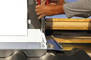 Residential Building Renovation Prints: Roofer works on the chimney cladding