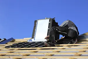 Construction Site Work Prints: Roofer works on the chimney cladding