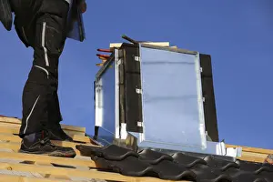 Construction Site Work Prints: Roofer works on the chimney cladding