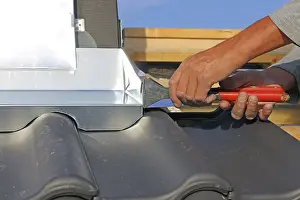 Roof Tile Installation Prints: Roofer works on the chimney cladding