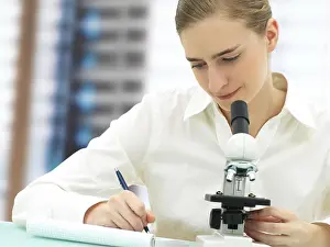 Female Scientist Microscope Prints: Scientist working with a microscope
