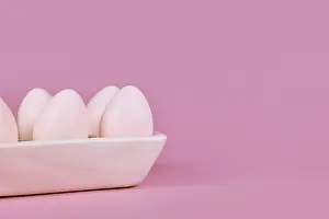 Colorful Decorative Items Prints: Simple one colored Easter eggs in egg tray on pink background with copy space