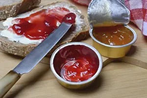Wooden Board Desserts Prints: Slice of bread with jam and jam in portion pack
