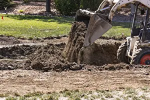 Building A Swimming Pool Prints: Small bulldozer digging in yard for pool installation