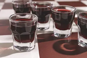 Table Setting Prints: There are small glasses with a red drink on the table