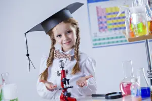 Female Researcher Prints: Smiling little chemist posing with microscope