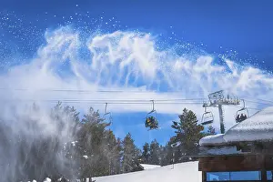 Prints of Snow cannon spreading fresh snow powder on a ski slope. Skiers riding up on chair lift. Winter ski holidays in El Tarter, Andorra, Pyrenees Mountains Andorra Prints: Snow cannon spreading fresh snow powder on a ski slope Print