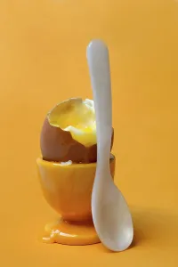 Plain Yellow Background Prints: Soft boiled breakfast egg in egg cup with spoon
