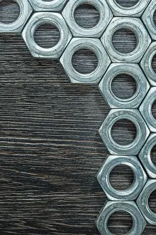 Industrial Construction Industry Prints: Stack of construction nuts on wooden board