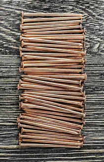 Wooden Board Prints: Stack of copper nails on wooden board
