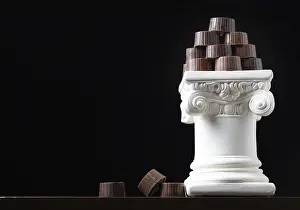 Bakery Display Case Prints: Stack of fine artisan chocolates stacked on white pillar column