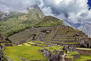 Inca City Peru Prints: Stepped terraces with ruins against a dramatic mountain backdrop full of clouds