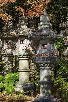 Prints of Stone lanterns in the forest in sunlight, decorated with small figures, Osaka, Japan Osaka Prints: Stone Lanterns in Forest Sunlight Print, Osaka, Japan