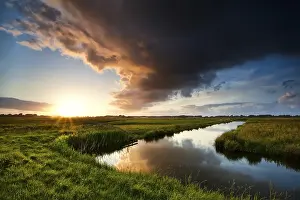 Stormy Atmosphere Prints: Storm cloud at dramatic sunset in summertime