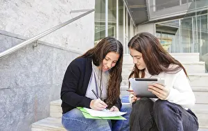 Young People Studying Together Prints: Two students sit on steps outside