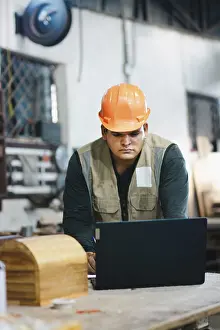 Carpenter Workshop Prints: Successful worker using a computer in the carpentry workshop
