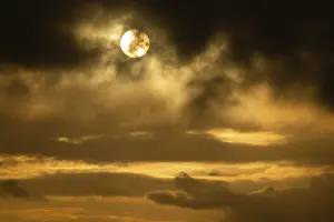 Empty Beach At Sunset Prints: Sun bursts out from behind clouds