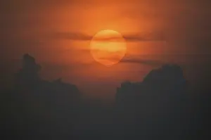 Uninhabited Evening Landscape Prints: Sun disk through the clouds at sunset above the horizon