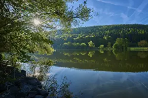 Historic Fortification Germany Europe Prints: Sun rays through the trees are reflected in the quiet river under a clear sky