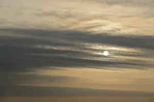 Central European Skies Prints: Sun shines behind layered clouds