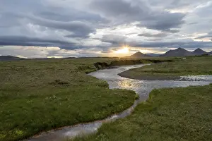 Cloudy Evening Skies Prints: Sunset between clouds, river flowing through meadows