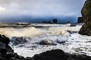 Rocky Coastal Area Prints: Surf, with dramatic cloudy sky, Vik, Iceland