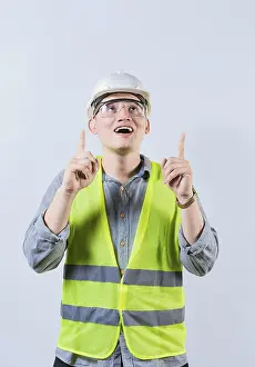 Young Architect Prints: Surprised young architect pointing up