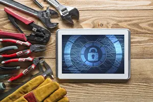Safety Precautions In Industry Prints: Tablet pc with security concept on screen and industrial tools around