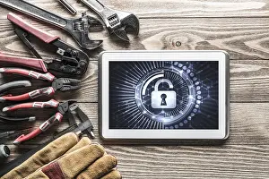 Tablet Pc Security Concept Prints: Tablet pc with security concept on screen and industrial tools around