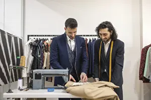 Sewing Tools Prints: Tailor in a suit store work on fabric with precision