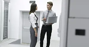 Server Room Technician Prints: Technicians using laptop while analyzing server in server room
