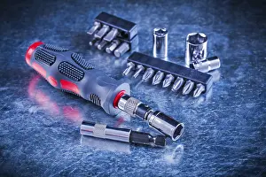 Handicraft Industry Prints: Turn screw with set of replaceable bits and torx on scratched metallic background construction concept